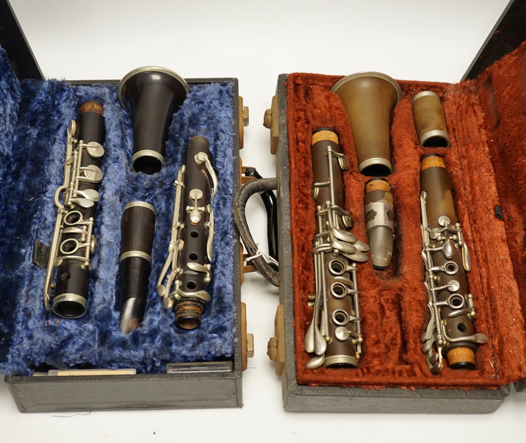 Two cased unmarked clarinets with early key systems, one mid 19th century in rosewood, one with light brown Bakelite body